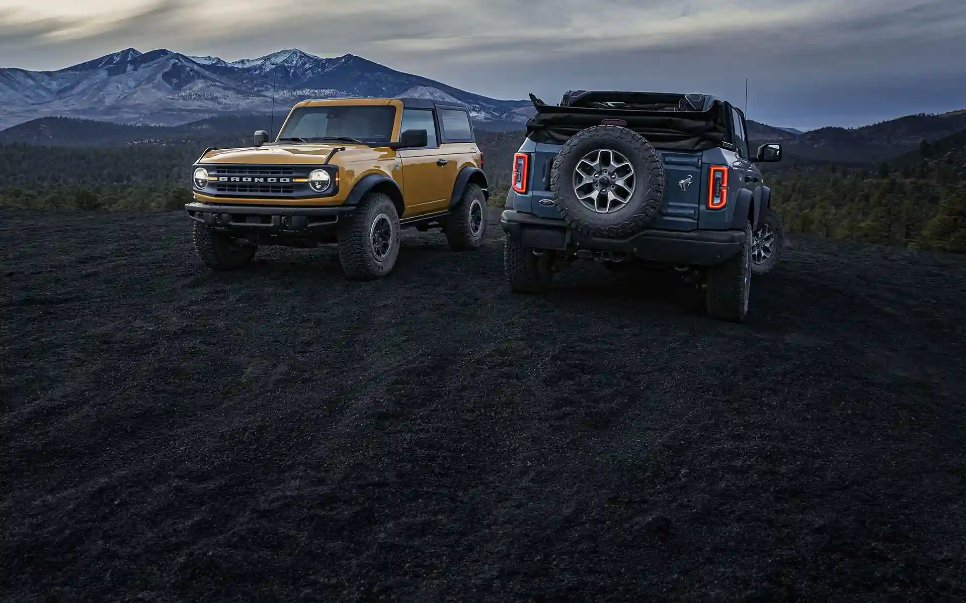 Two ford cars parked in mountains at dawn